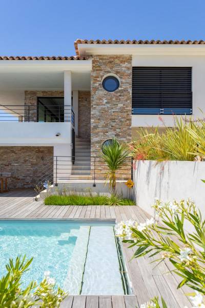 Réalisation d'une terrasse en bois exotique à  Bandol avec agrandissement d’une plage de piscine en bois exotique et création de marche d’accès à la maison.